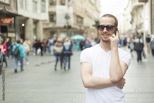 Man with sunglasses and cell phone walking