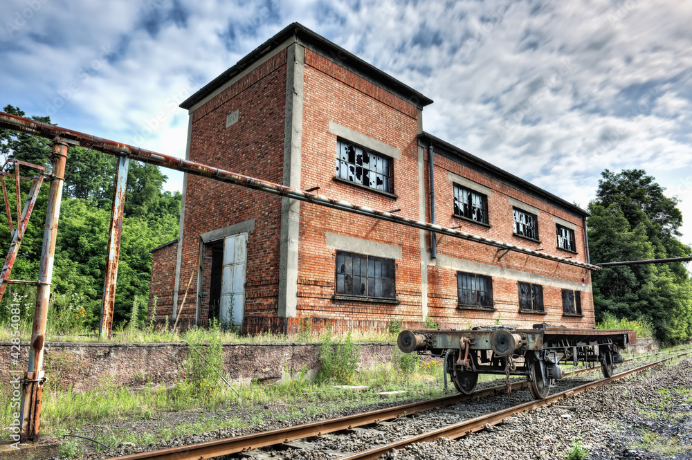 Abandoned railcar in front of an old industrial building Abandoned railcar in front of an old industrial building