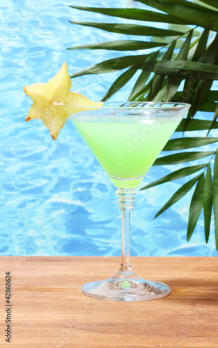 Glass of cocktail on blue sea background