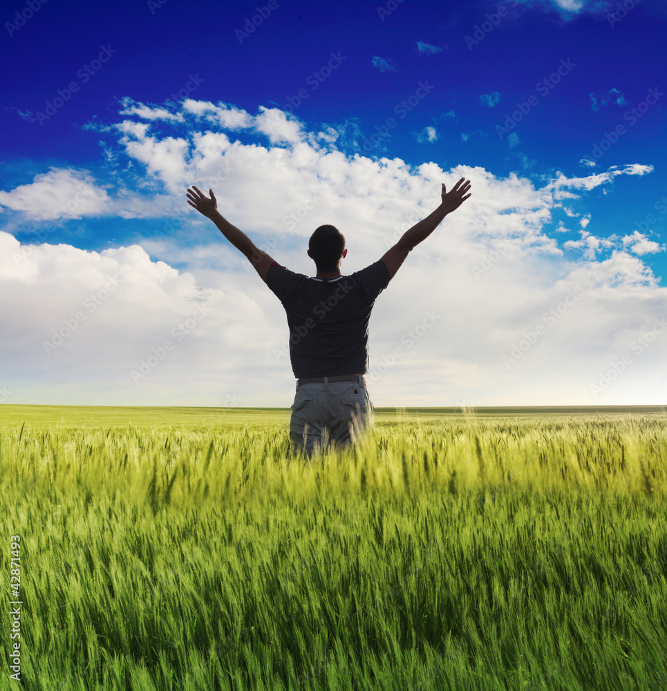 man standing on the green field under blue sky man standing on the green field under blue sky