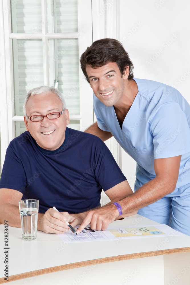 Mature Man playing Sudoku Puzzle Mature Man playing Sudoku Puzzle