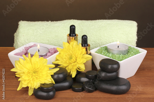 Spa setting on wooden table on brown background