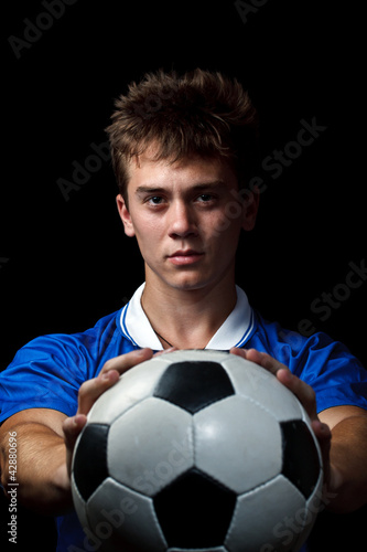Soccer player is holding ball