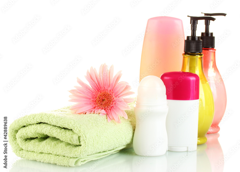 cosmetics bottles with towels and flower isolated on white