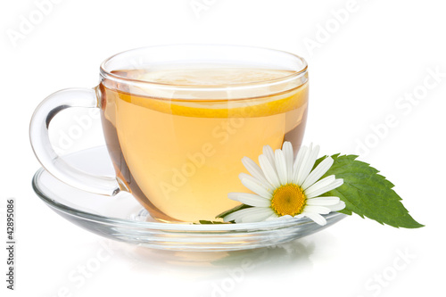 Cup of tea with lemon slice, mint leaves and chamomile flower