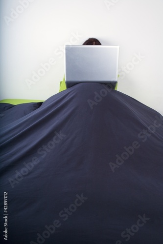 фотографія laptop on top bedcover mountain