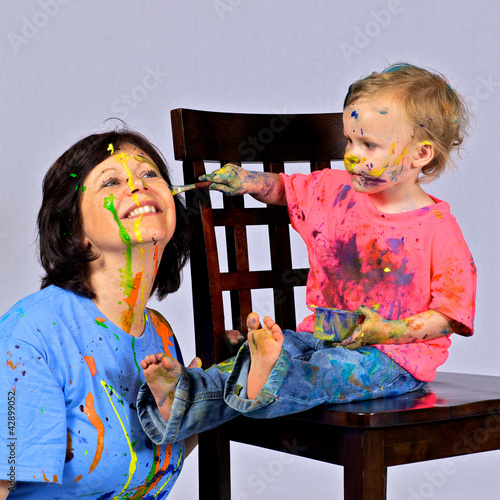Toddler paints her grandmother’s face.