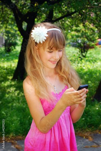 young girl with mobile phone in park