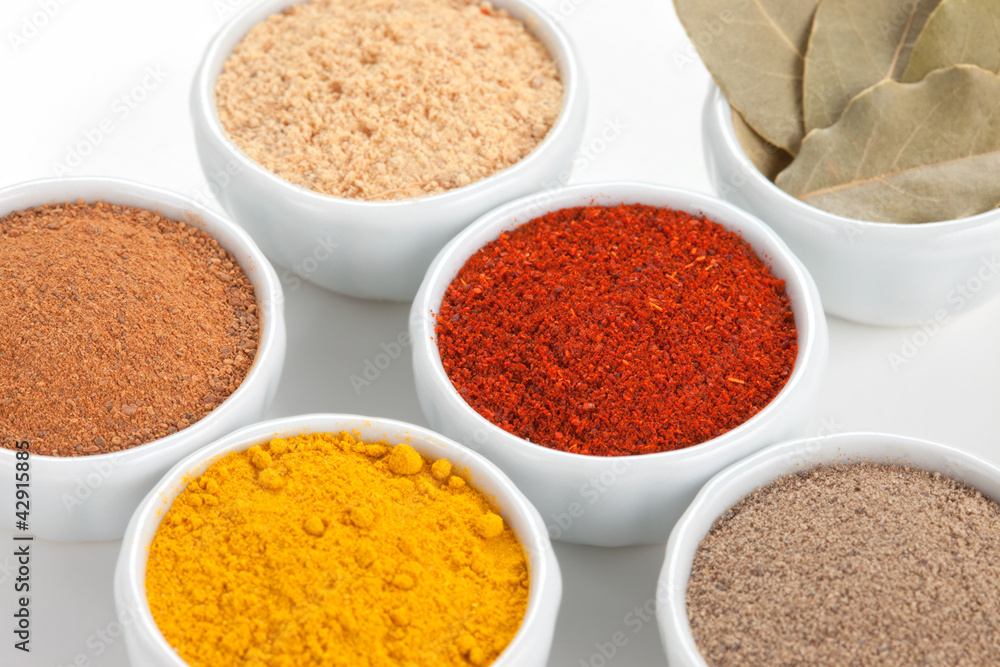 Different spices in white bowls isolated on white background. Different spices in white bowls isolated on white background.