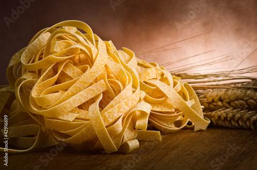 group of italian homemade pasta tagliatelle on wood photo