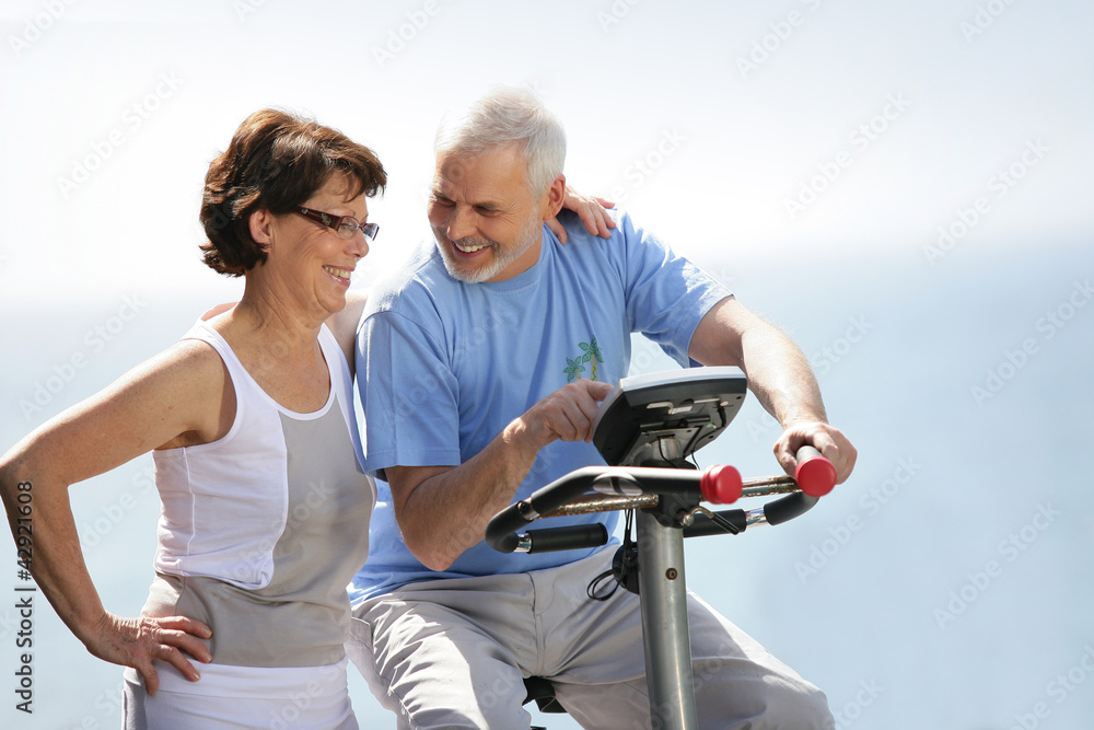 Senior couple with an exercise bike Senior couple with an exercise bike