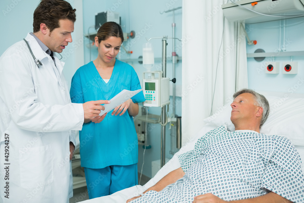 Doctor and nurse looking at a paper with a patient Doctor and nurse looking at a paper with a patient