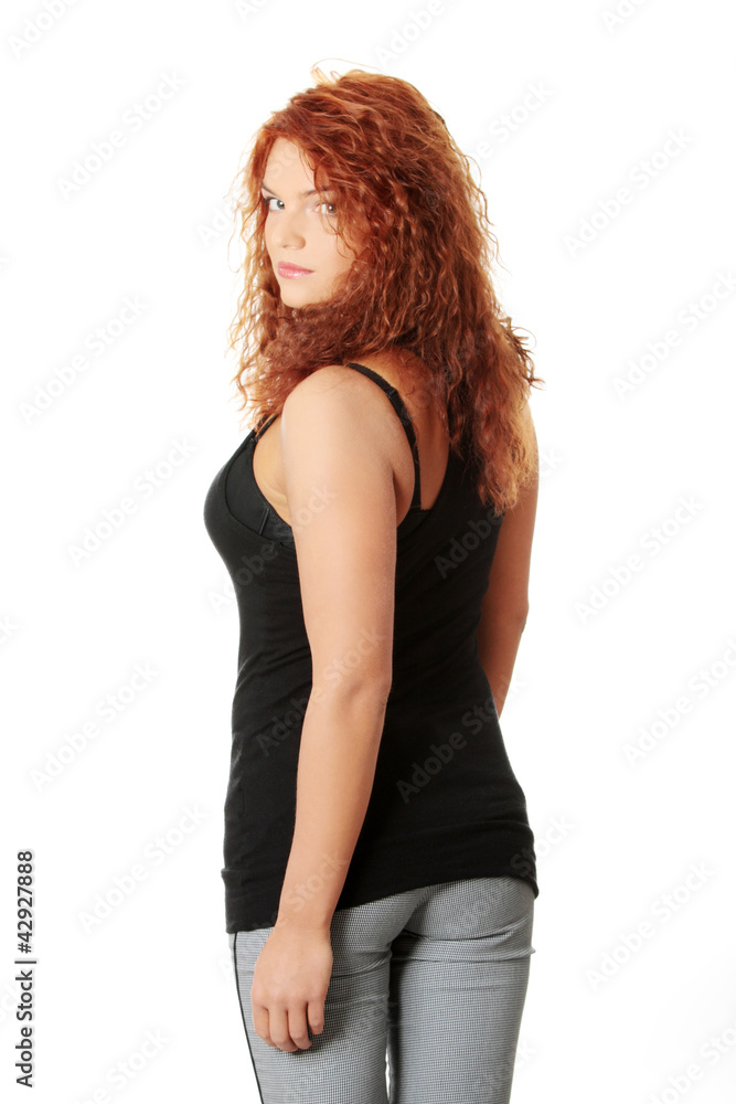 Young woman with long red hair is looking back. Young woman with long red hair is looking back.