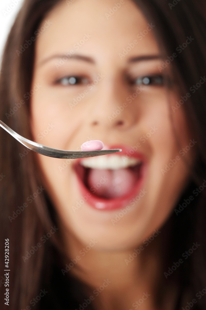 Happy woman eating pill using the fork. Happy woman eating pill using the fork.