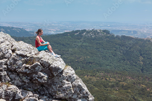 Young athletic girl relaxing on top of rocks © Luis Viegas