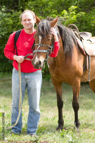 Handsome smiling man with horse in the forest © Forewer