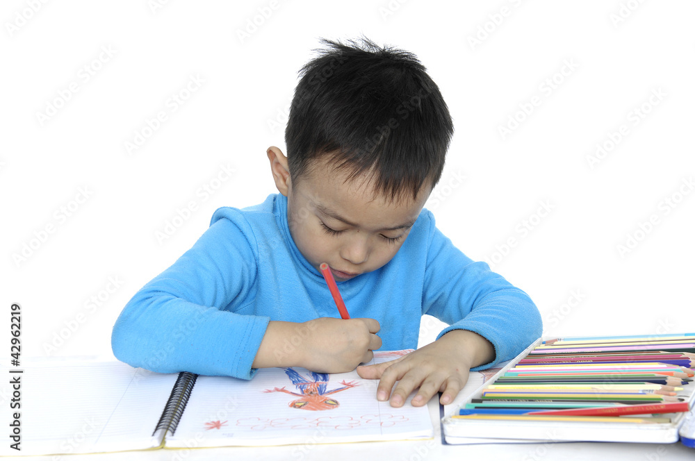 School little boy sitting and writing in books School little boy sitting and writing in books