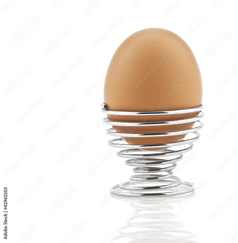 Boiled egg in silver spiral egg cup isolated on white background Boiled egg in silver spiral egg cup isolated on white background