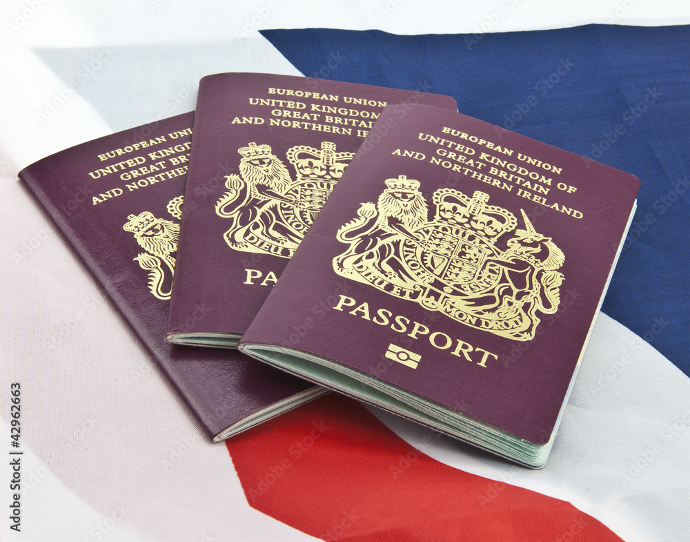 Three United Kingdom passports on folded Union Jack Flag Stock Photo ...