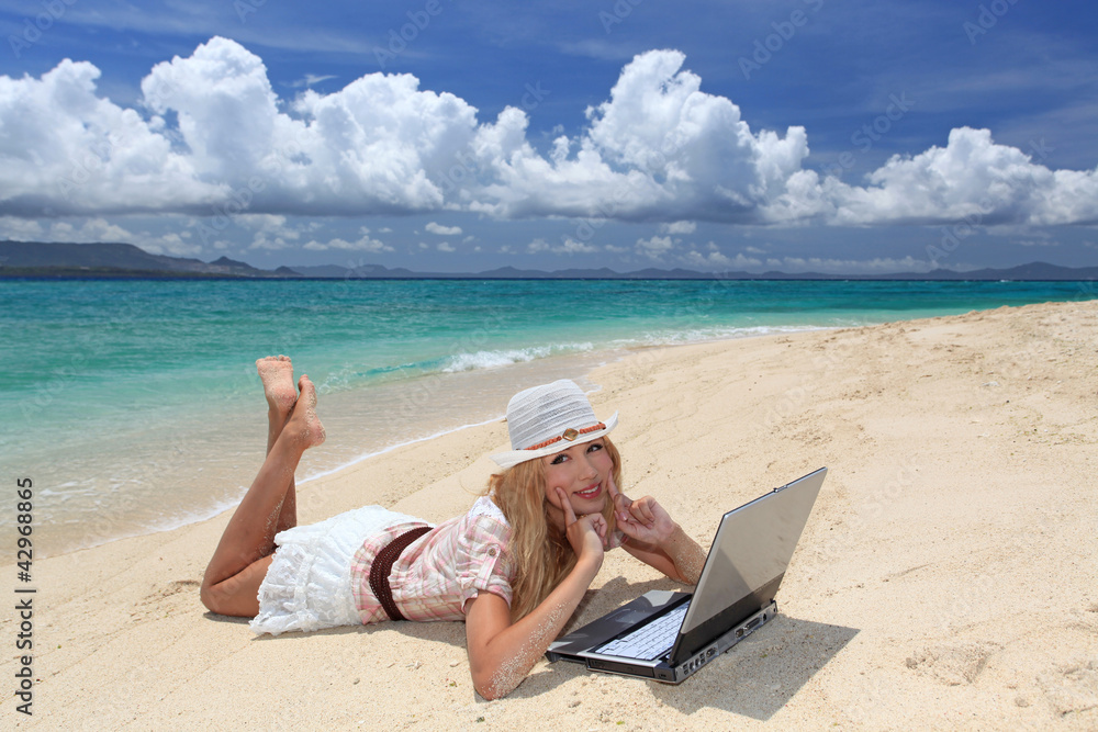 海辺でパソコンを楽しむ女性