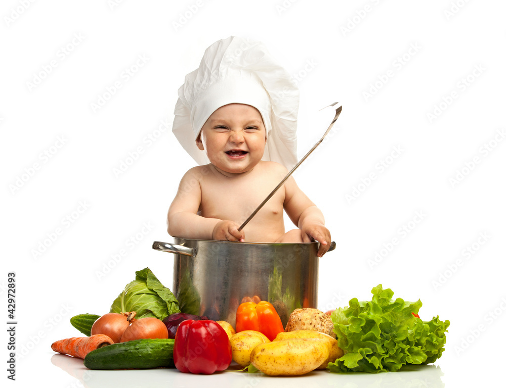 Little boy in chef's hat with ladle, casserole, and vegetables Little boy in chef's hat with ladle, casserole, and vegetables