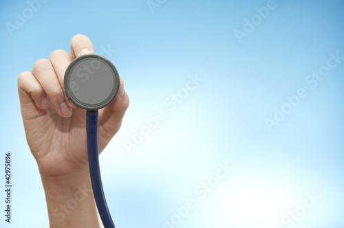 Stethoscope in young female doctor hand