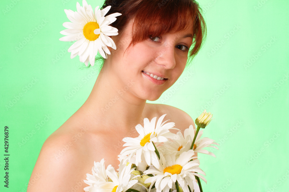 Smiling young girl with chamomile flowers