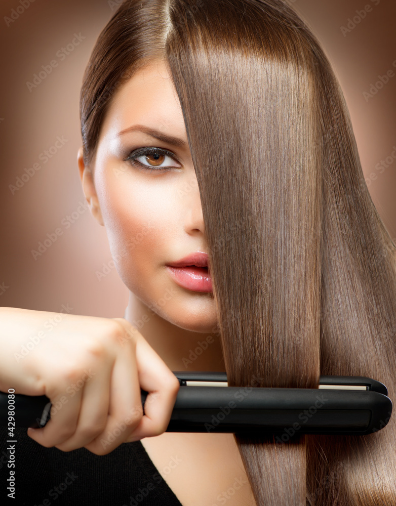 Fototapeta premium Hairstyling.Hairdressing.Hair Straightening Irons.Straight Hair