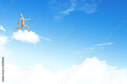 Wooden model run on cloud on the blue sky