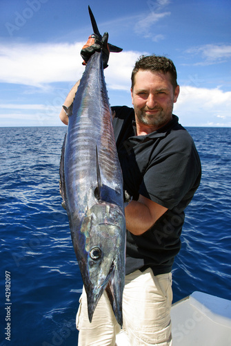 Lucky  fisherman holding a beautiful wahoo fish