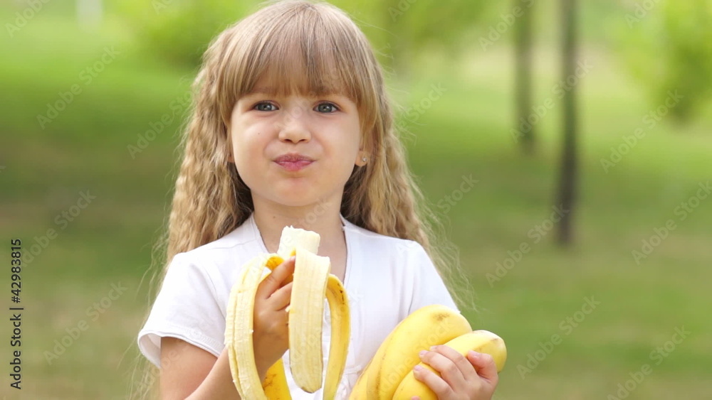 Child eating bananas outdoors Child eating bananas outdoors