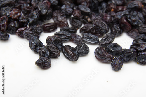 black raisins on a white background