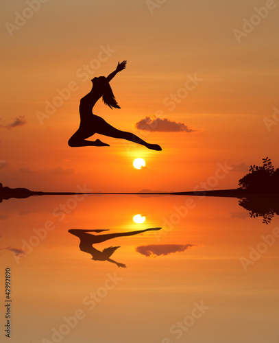 Silhouette of a beautiful ballet girl in sunset beach © Feelplus Creator