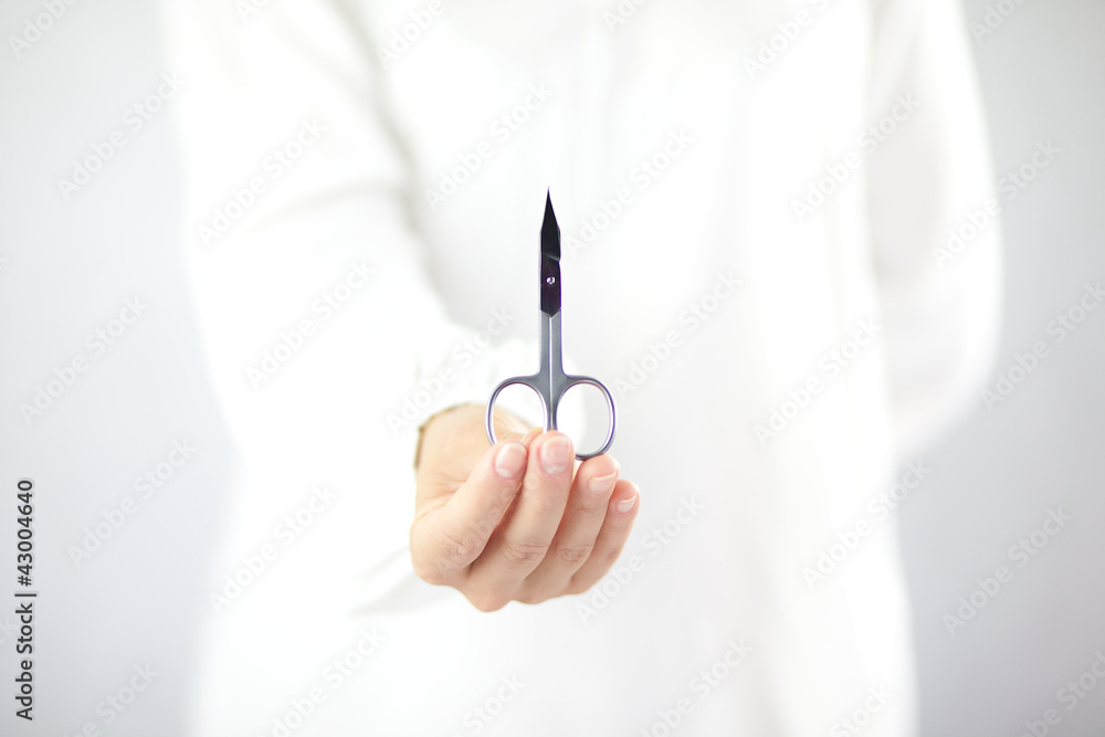 Kobieta trzymająca w ręku nożyczki do manicure - obrazy, fototapety, plakaty 