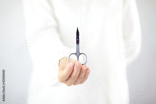 Kobieta trzymająca w ręku nożyczki do manicure