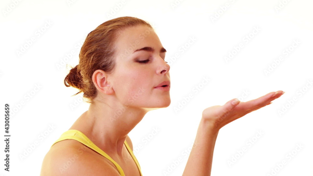 Young woman blowing something from her hand Young woman blowing something from her hand