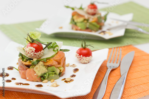 Avocado and salmon salad on square plate