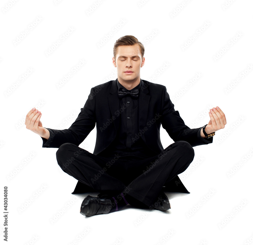 Smart young man in party wear doing yoga Smart young man in party wear doing yoga