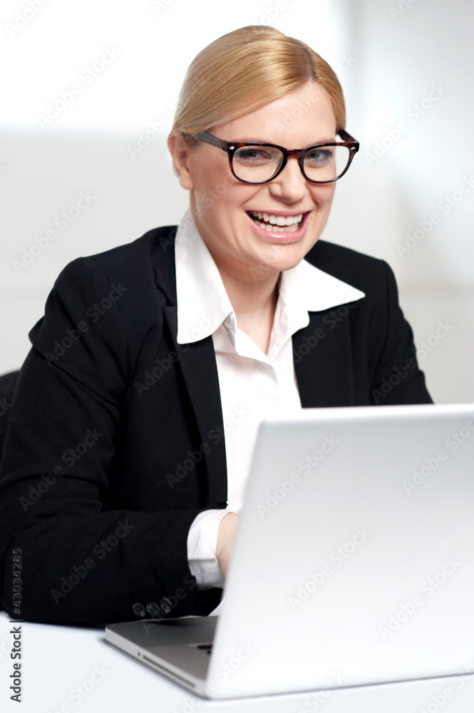 Smiling young female executive at work desk Smiling young female executive at work desk