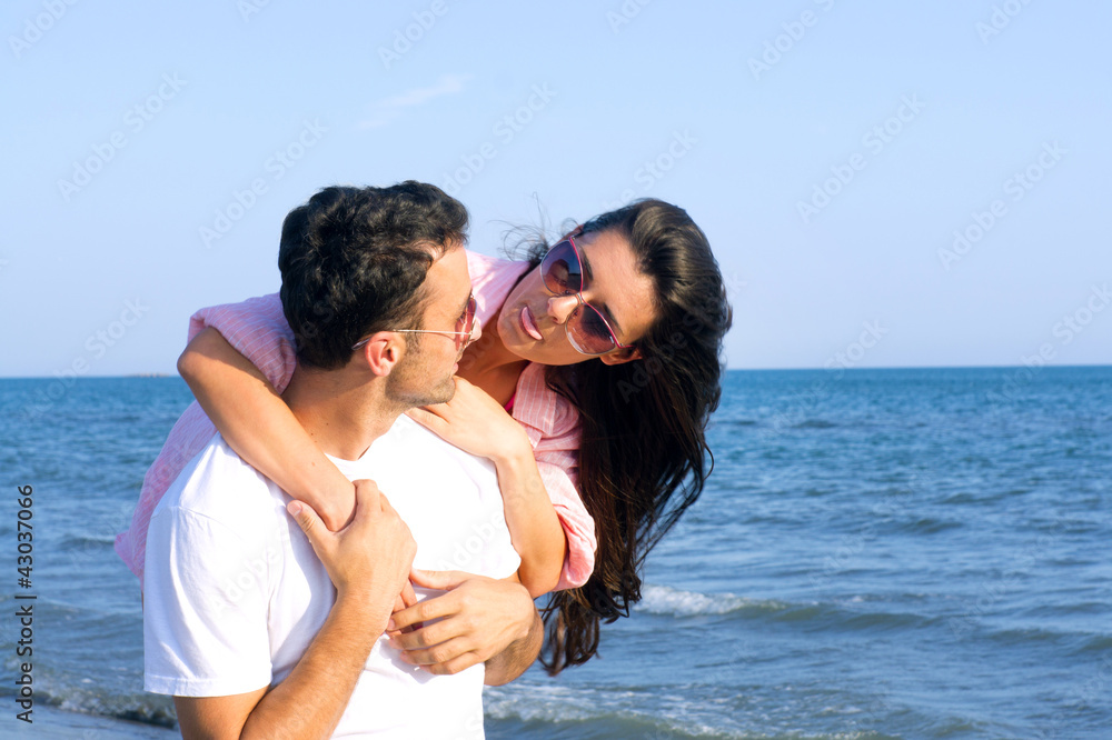 Happy couple at the beach in a playful mood Happy couple at the beach in a playful mood