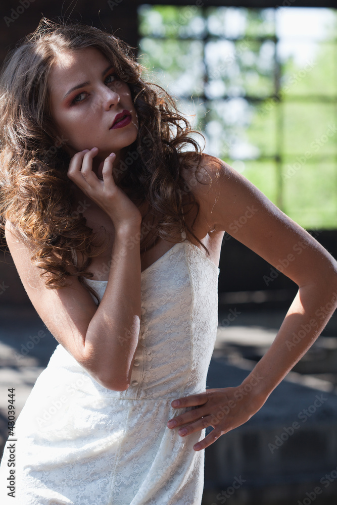 Young brunette posing against the backdrop of a building with l Young brunette posing against the backdrop of a building with l