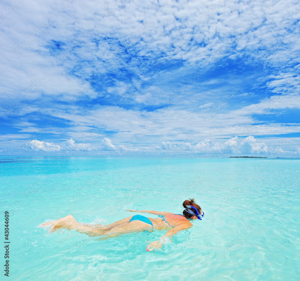 A woman with snorkeling mask diving