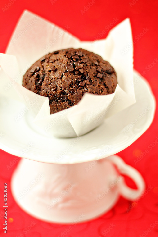 Vegan chocolate muffin on a white saucer Vegan chocolate muffin on a white saucer