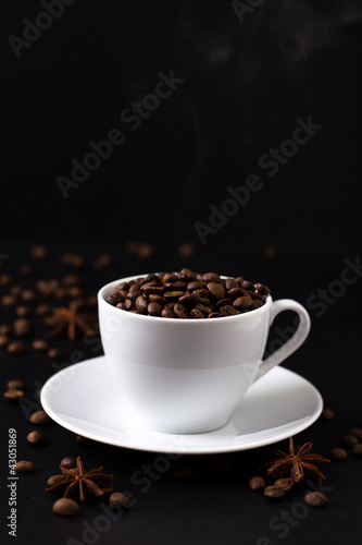 Coffee beans in white cup on black background