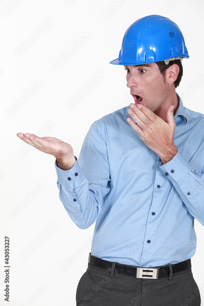 Surprised engineer looking at his palm Surprised engineer looking at his palm