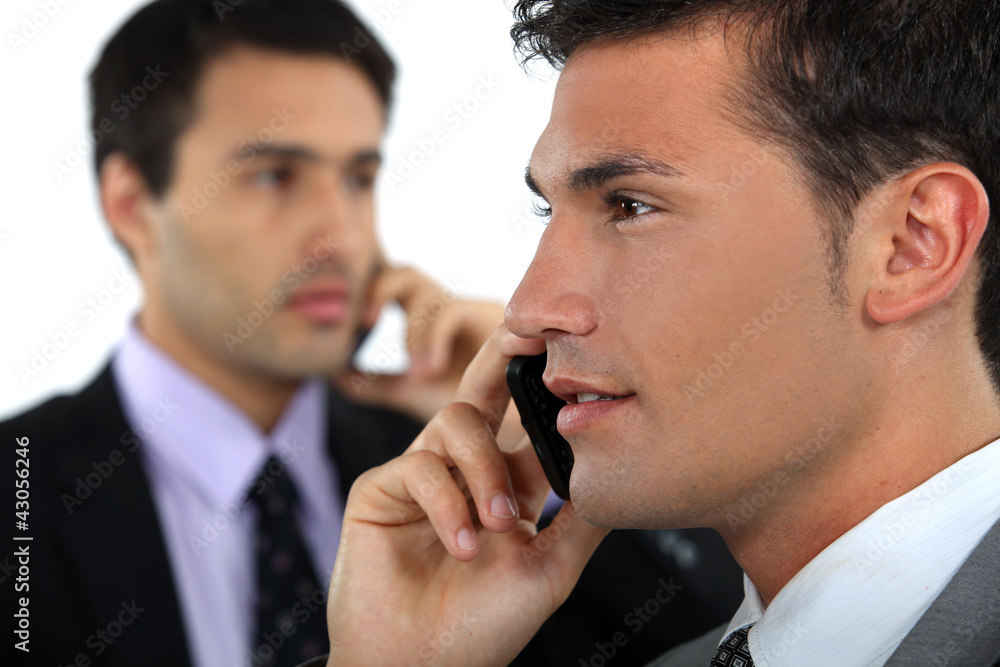 businessmen talking on their cell businessmen talking on their cell
