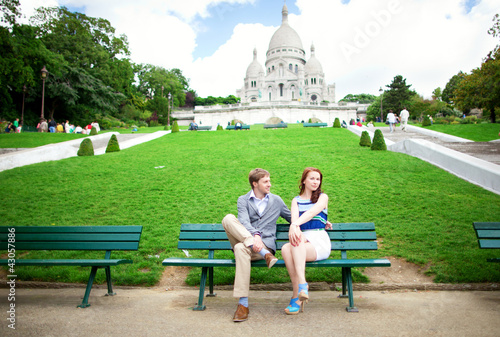Beautiful couple is sitting on the bench near the Sacre-Coeur ba