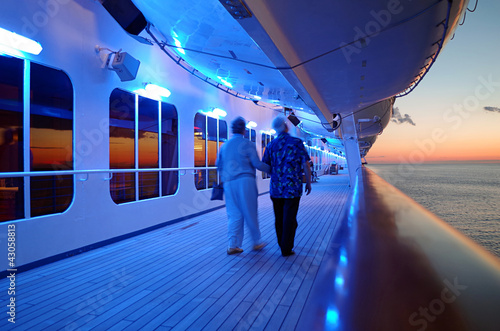 Elderly Couple Walking On Cruise Ship Deck in Evening