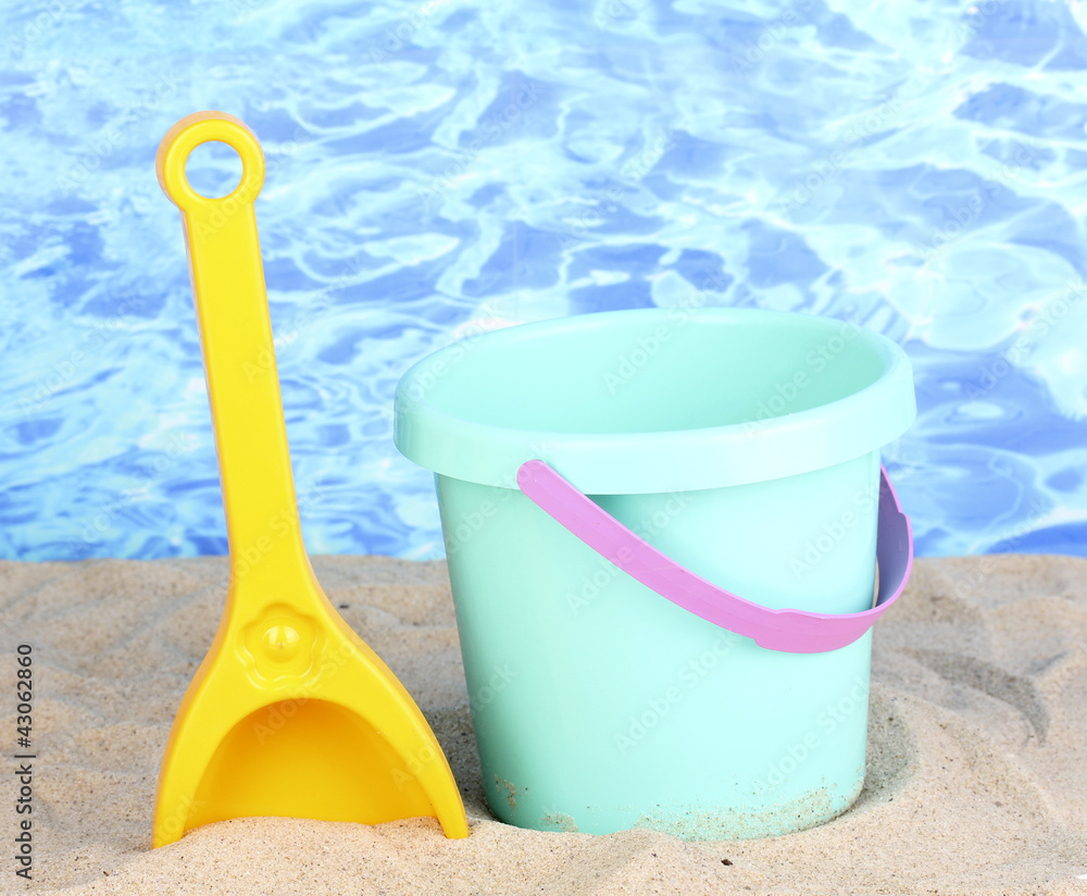 Children's beach toys on sand on water background Children's beach toys on sand on water background