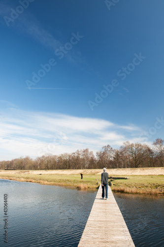 Man walking away over water photo